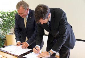 Patricio Donoso, prorrector de la UC, junto a Diego Artigas, representante legal de Integration Consultoría Empresarial Chile Ltda., firmando el acuerdo.