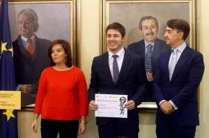 Exalumno Gonzalo Jara (al medio en la foto) recibiendo el título del programa junto a la vicepresidenta del gobierno español Soraya Sáenz de Santamaría y al director de Fundación Carolina Jesús Andreu.