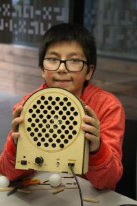Alumno FabLab mostrando parlante de música hecho por él